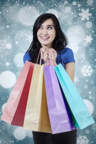 Junge Shopperin mit Schneeflockenhintergrund — Stockfoto