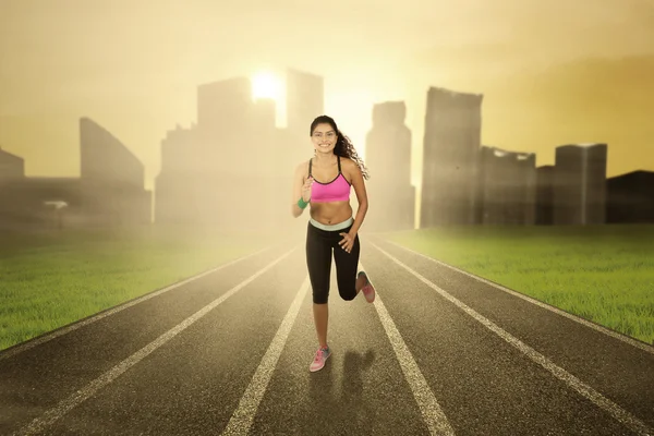 Woman with sportswear runs at field — Stock Photo, Image