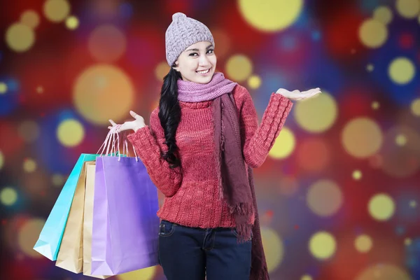 Vrouw met shopping tassen en bokeh achtergrond — Stockfoto