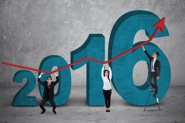 Equipe de negócios segurar gráfico financeiro com números 2016 — Fotografia de Stock