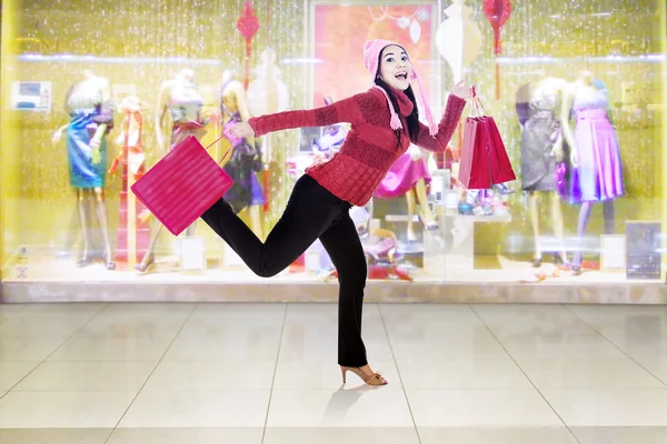 Весела жінка з зимовим одягом працює в торговому центрі — стокове фото