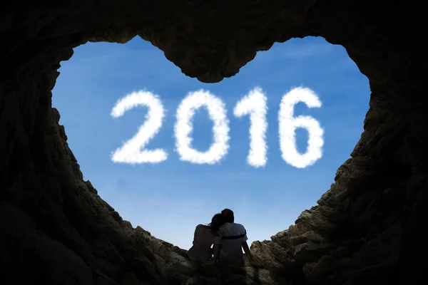 Couple sitting inside cave with numbers 2016 — Stock Photo, Image