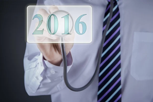 Médico usando estetoscópio para tocar números 2016 — Fotografia de Stock