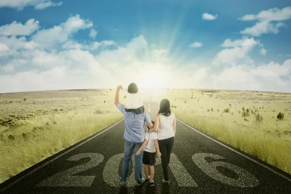 Familia caminando por la carretera con números 2016 — Foto de Stock