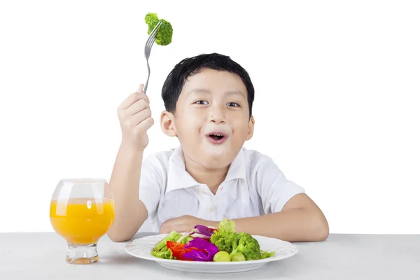 Niño feliz comiendo brócoli — Foto de Stock