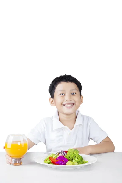 Niño pequeño con su ensalada y jugo de naranja — Foto de Stock