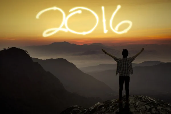 Man står på bergstoppen med nummer 2016 — Stockfoto
