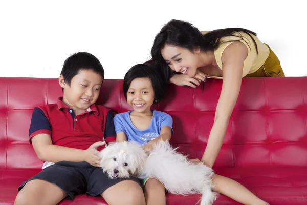 Alegre niños jugando cachorro con mamá — Foto de Stock