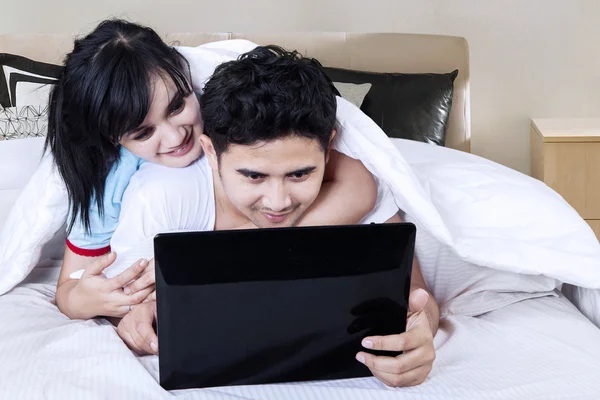 Couple use laptop in hotel bedroom — Stock Photo, Image