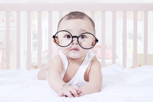 Roztomilé dítě nosit brýle v ložnici — Stock fotografie