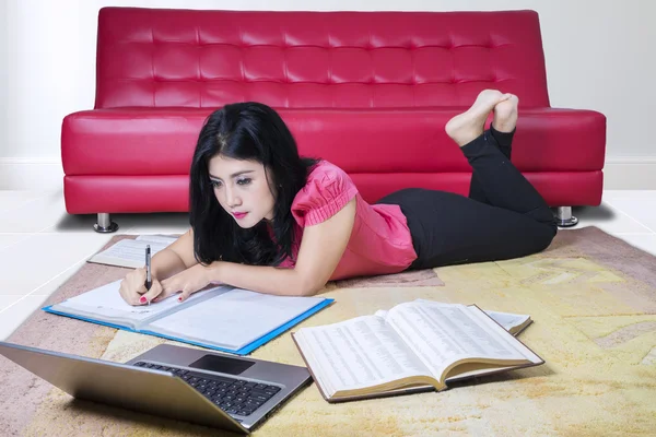 Studentin schreibt an den Büchern — Stockfoto