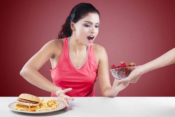 Mädchen trifft Wahl zwischen Burger und Erdbeere — Stockfoto