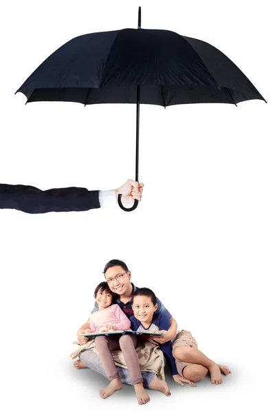 Çocuk ve baba okuma kitabı şemsiyesi altında — Stok fotoğraf