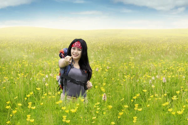 Girl on meadow pointing at camera — Stock Photo, Image