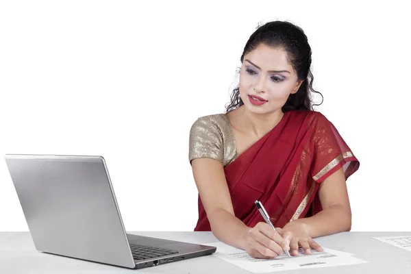 Mujer india que trabaja con el ordenador portátil mientras escribe —  Fotos de Stock