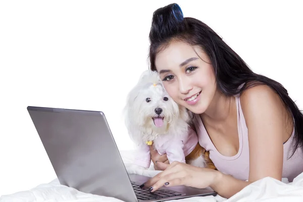 Bella donna con computer portatile e cane sul letto — Foto Stock