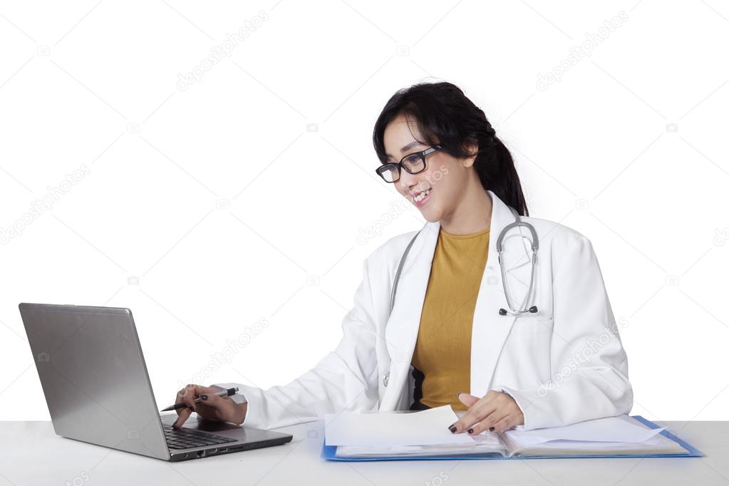 Pretty young doctor working with laptop
