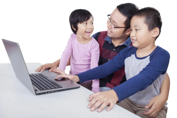 Deux enfants étudient avec un ordinateur portable et leur professeur — Photo