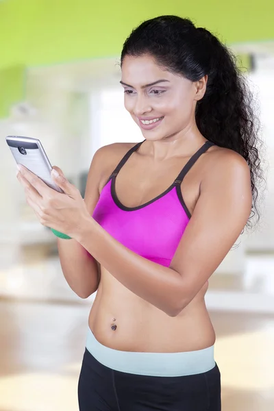 Donna con abbigliamento sportivo con smartphone — Foto Stock