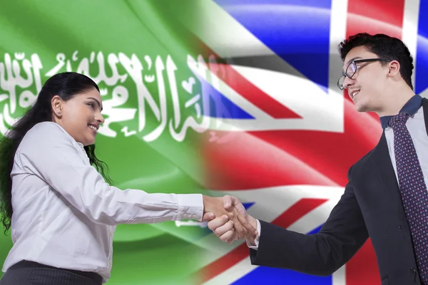 Mujer árabe estrechando la mano con persona británica — Foto de Stock