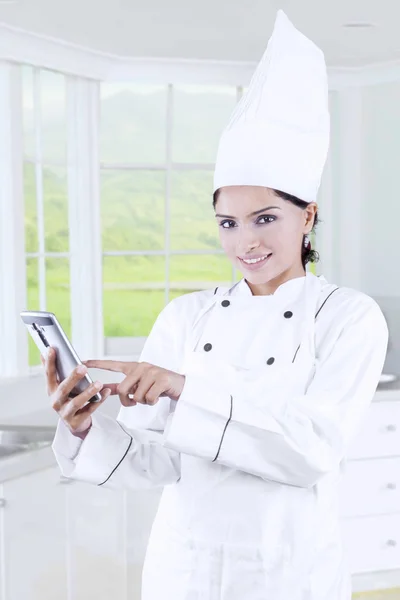 Chef-kok met behulp van mobiele telefoon in de keuken — Stockfoto