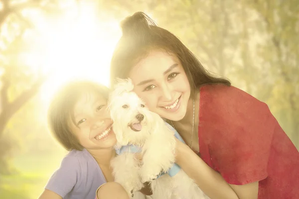 Menina feliz e mãe com cão no parque — Fotografia de Stock