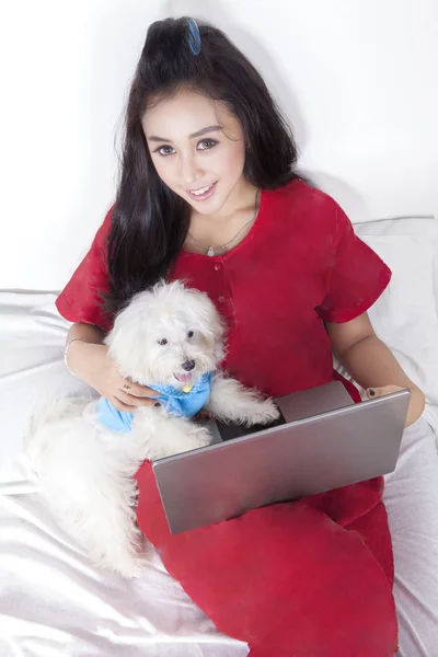 Mujer con pijama y perro usando laptop — Foto de Stock