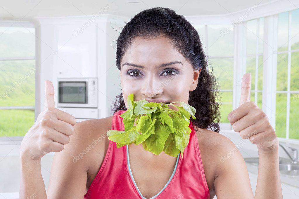 Woman eats spinach at home