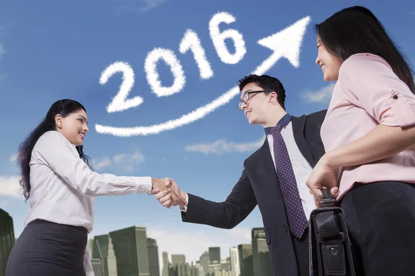 Workers handshaking with number 2016 background — Stock Photo, Image