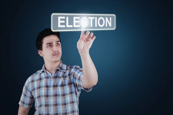 Young man touching election button — 图库照片