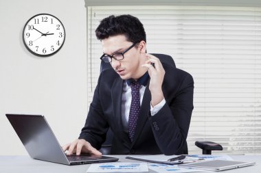 Busy worker using laptop at workplace