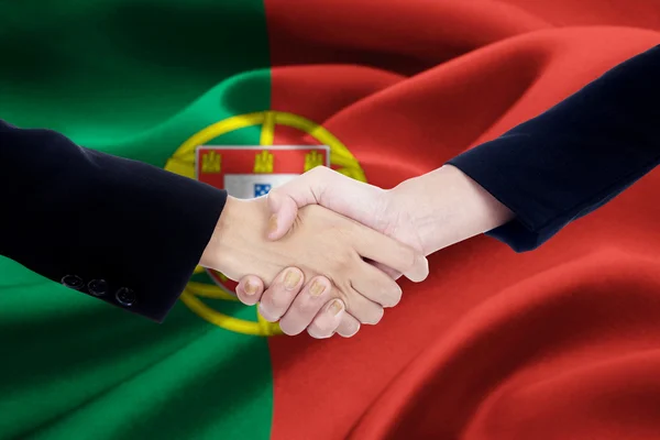 Agreement handshake with flag of Portugal — стокове фото