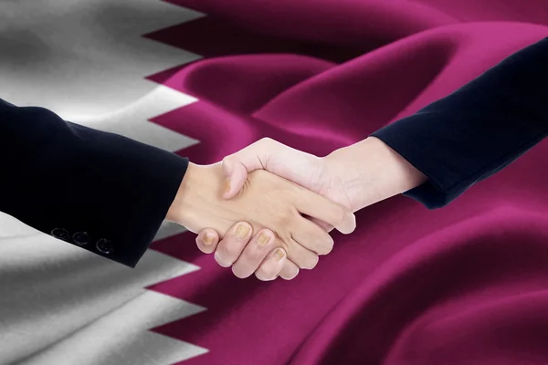 Agreement handshake with flag of Qatar — 스톡 사진