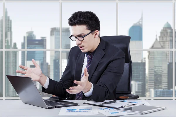 Confused worker looking at notebook screen — Stok fotoğraf