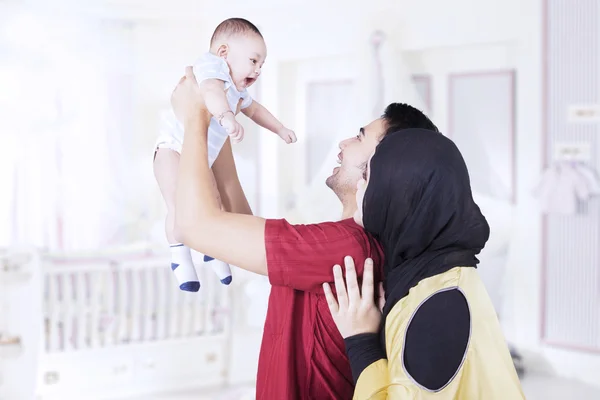 Schattige baby bij zijn ouders in de slaapkamer — Stockfoto