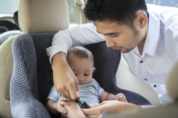 Vater setzt Baby in Autositz — Stockfoto