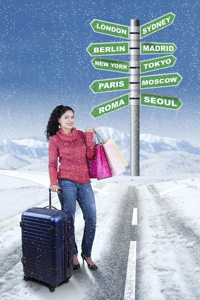 Woman with road sign of destination place to holiday — Stock Photo, Image
