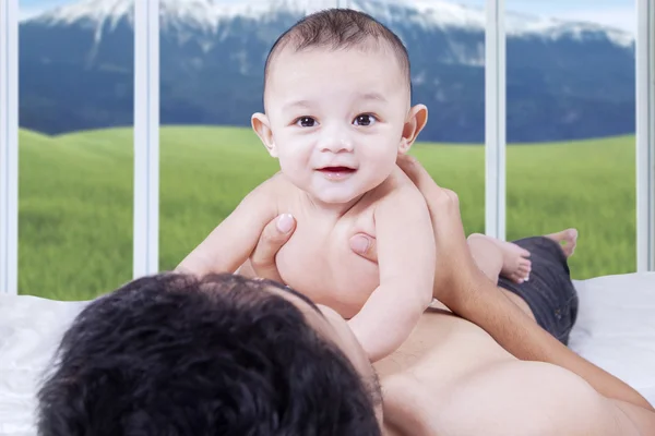 Adorable bebé macho acostado en el estómago del padre —  Fotos de Stock