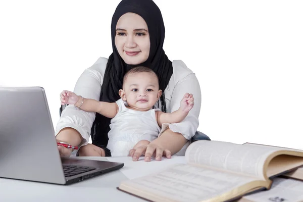 Занятая мать использует ноутбук со своим ребенком — стоковое фото