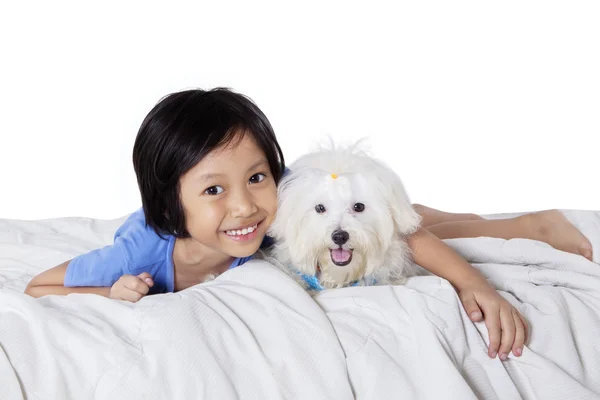 Chica divirtiéndose con cachorro en la cama —  Fotos de Stock