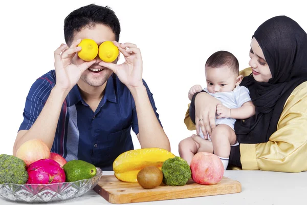 Šťastní rodiče a dítě s čerstvým ovocem — Stock fotografie
