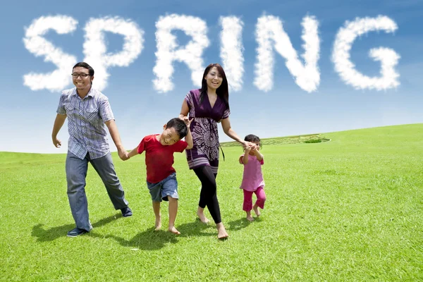 Preciosa familia joven corriendo en el prado — Foto de Stock