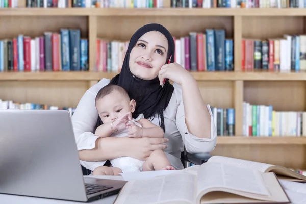 Madre y bebé soñando en la biblioteca —  Fotos de Stock