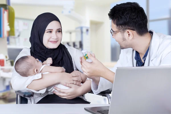 Pediatra explicando medicamentos a la madre — Foto de Stock