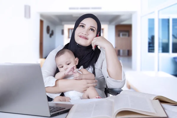 Mère pensive avec bébé et ordinateur portable — Photo