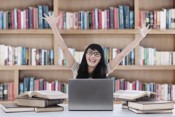 Estudante expressando felicidade na biblioteca — Fotografia de Stock