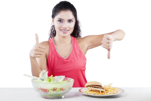 Mujer eligiendo entre ensalada y comida chatarra —  Fotos de Stock