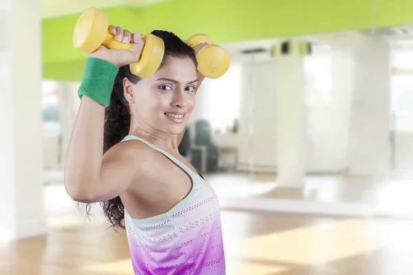 Woman trains her biceps with dumbbells — Stock Photo, Image