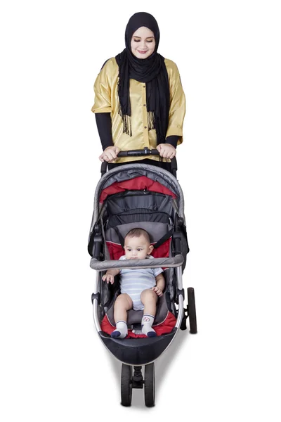 Jovem mãe empurrando bebê com carrinho — Fotografia de Stock