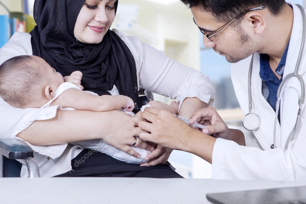 Pediatrician giving vaccine to baby boy